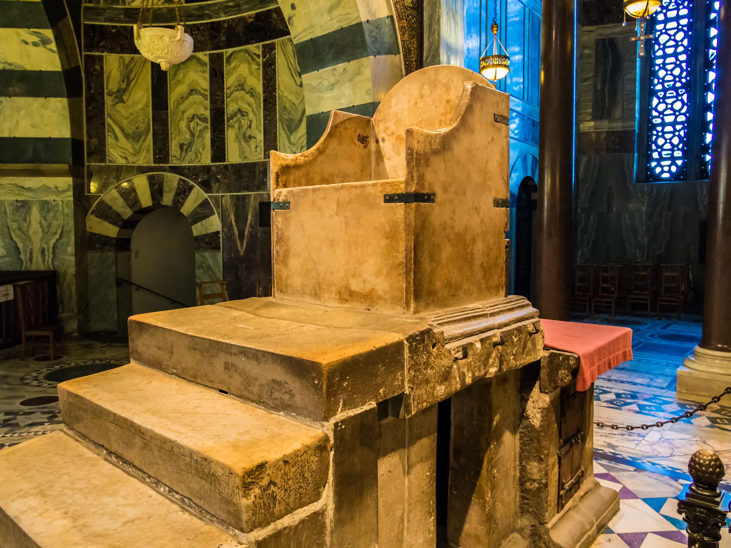 Plain marble steps leading up to a seat with an altar behind