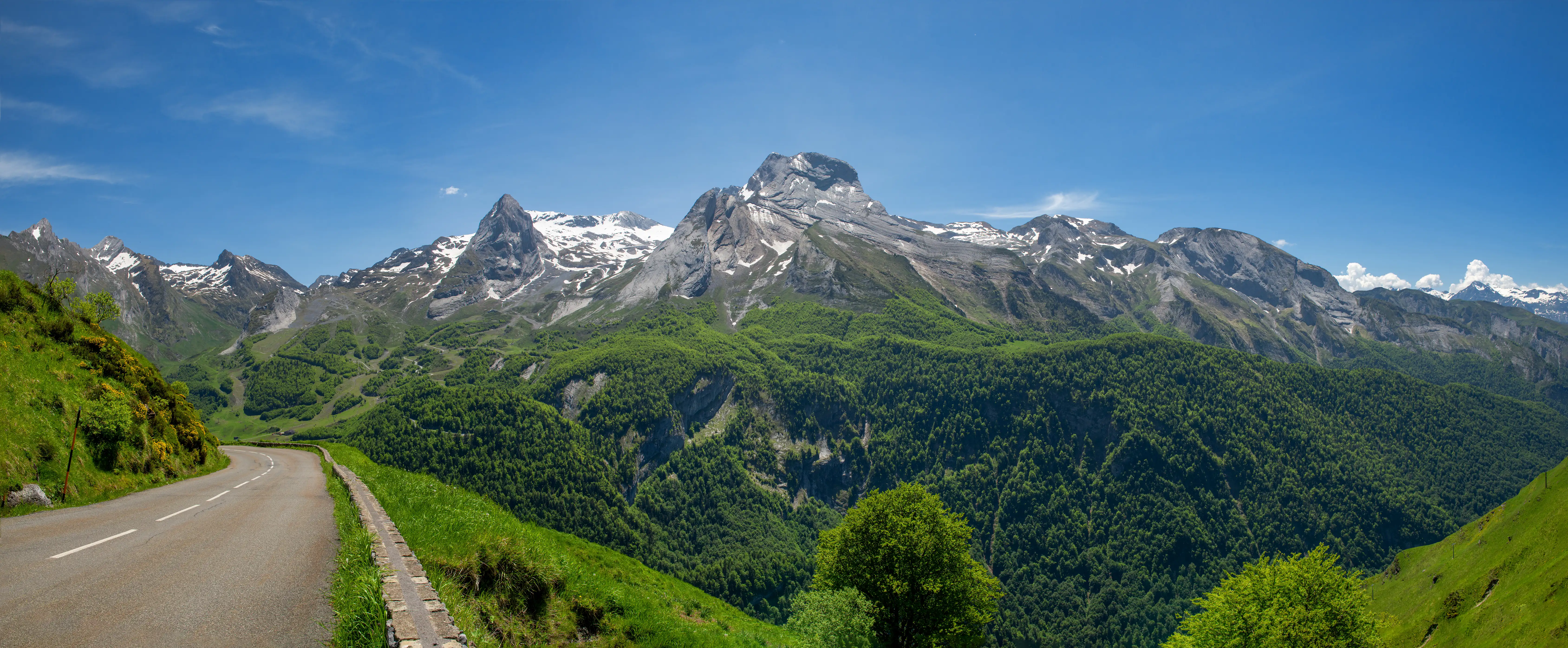 A road heads towards a snow-capped mountain range