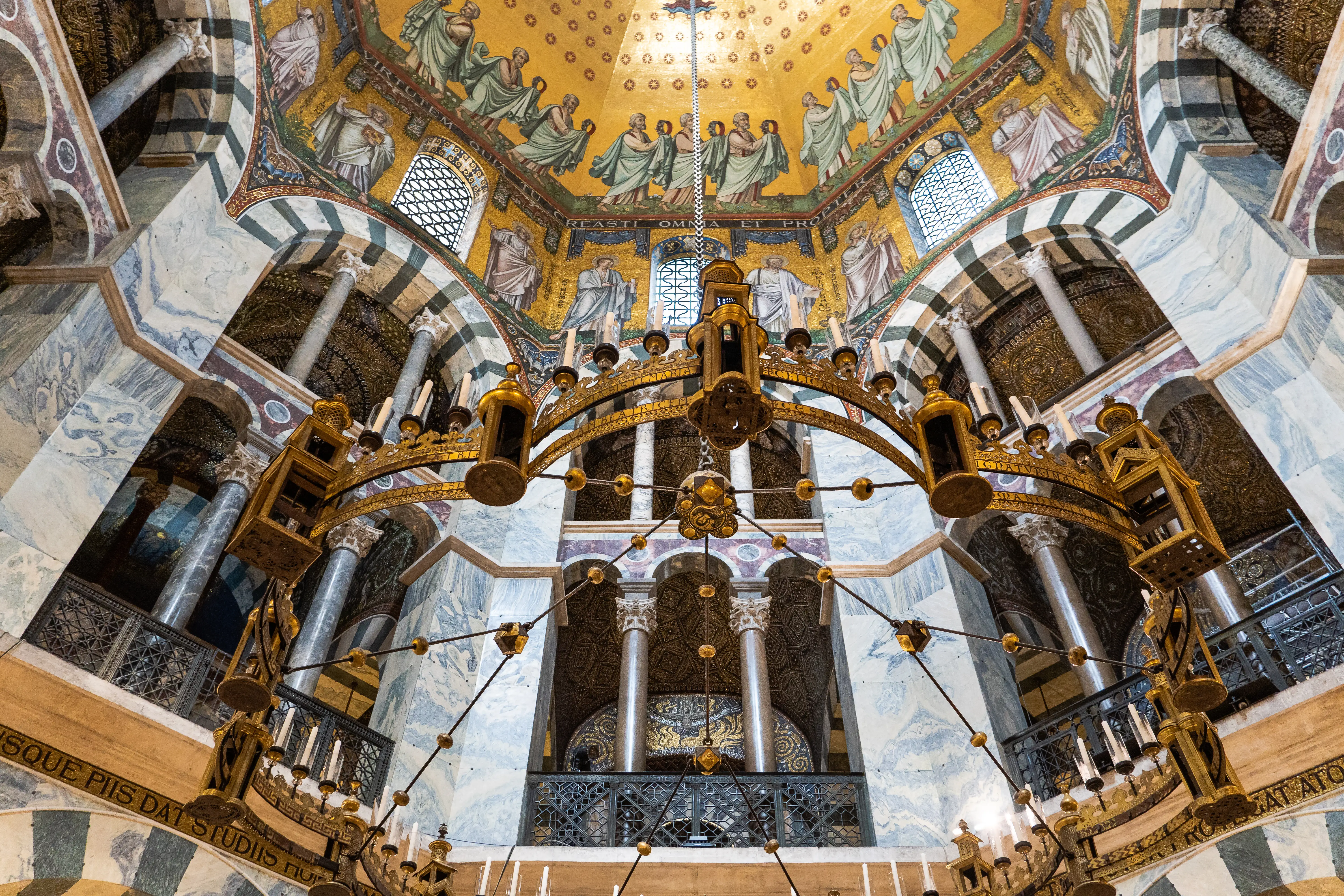 Sumptuously decorated interior of a religious building, with marble columns, chandelier and frescos