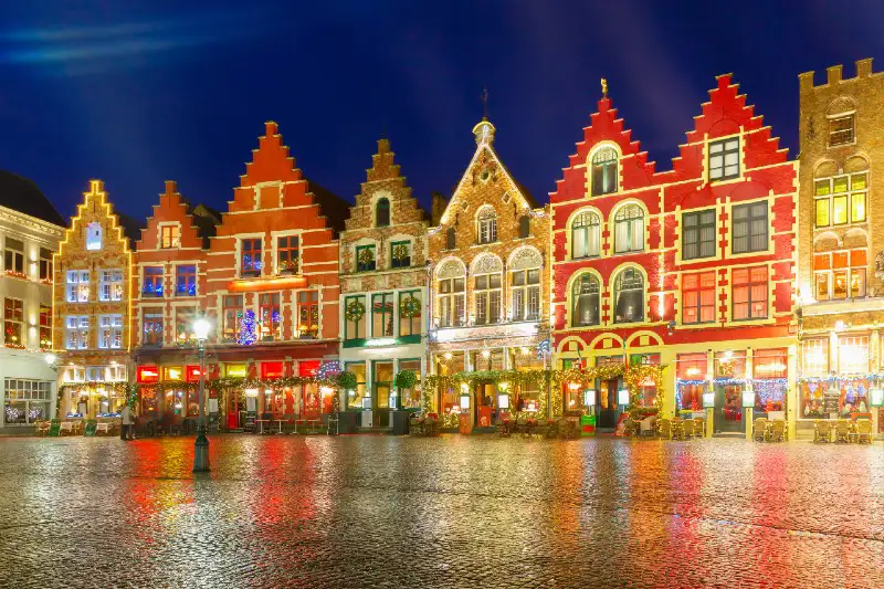 A serene view of a city square illuminated at night, showcasing historic buildings and a tranquil atmosphere.