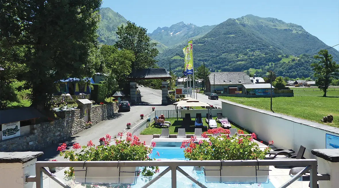 Swimming pool with mountains in background and flowers in the foreground
