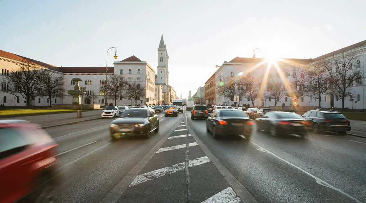 A: Cars driving on a three lane city centre road in Europe