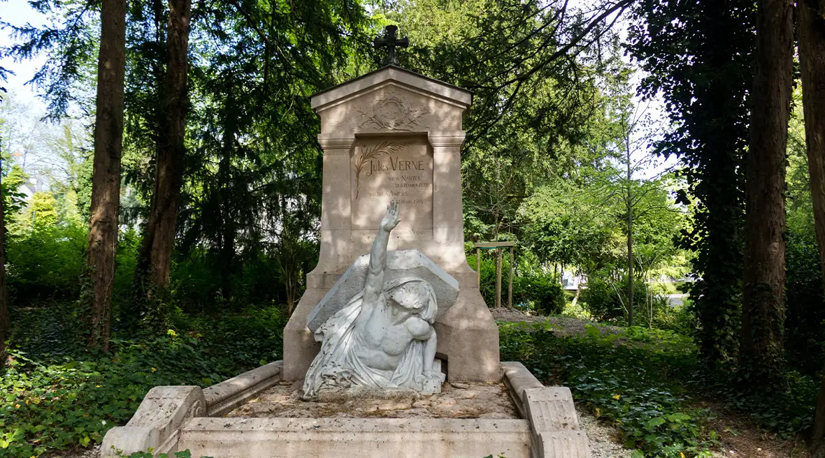 A stone sculpture showing a figure breaking out of a coffin at a cemetery monument