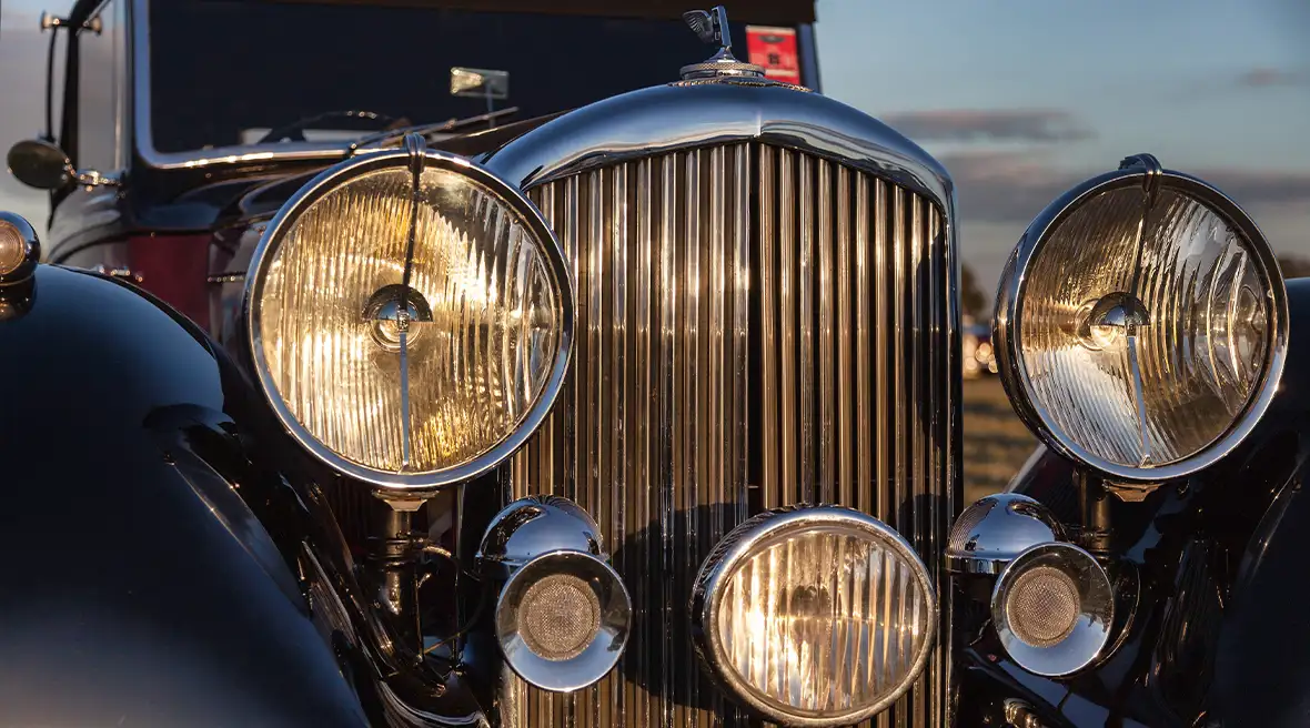 Close-up van een vintage Bentley, met de koplampen aan