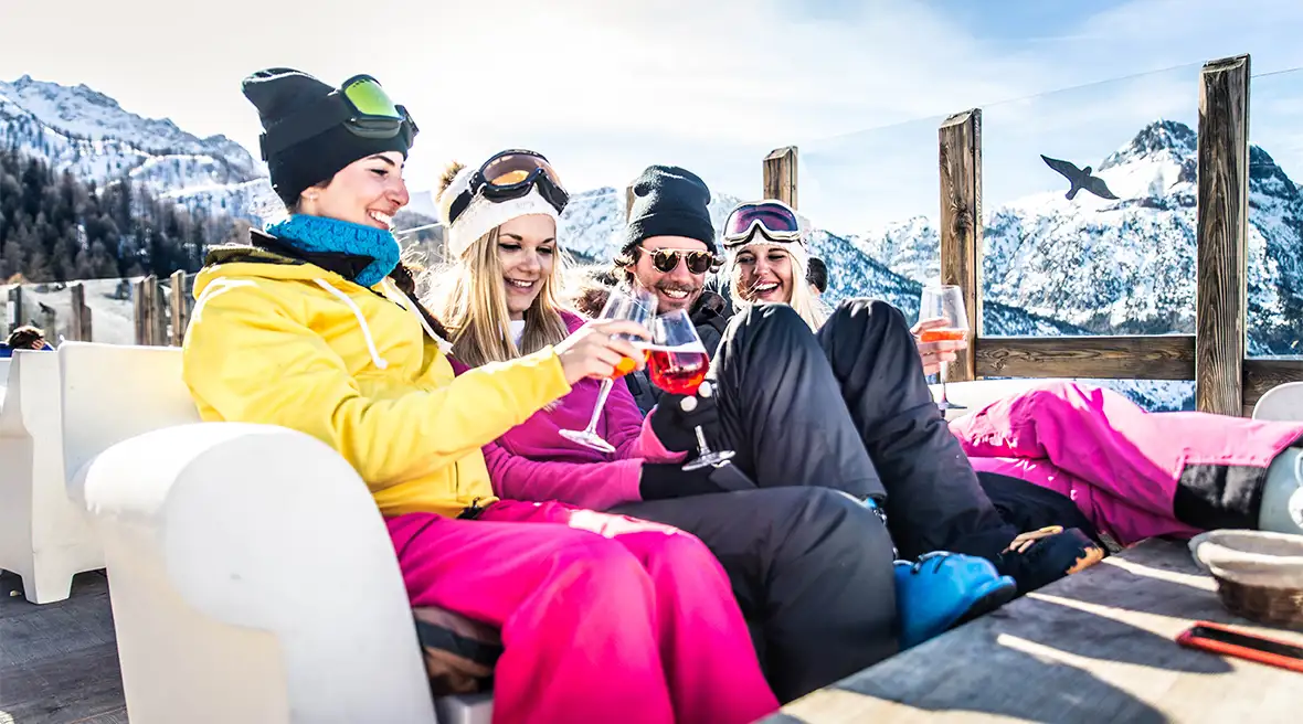Skiers relaxing with drinks at a bar on a ski slope