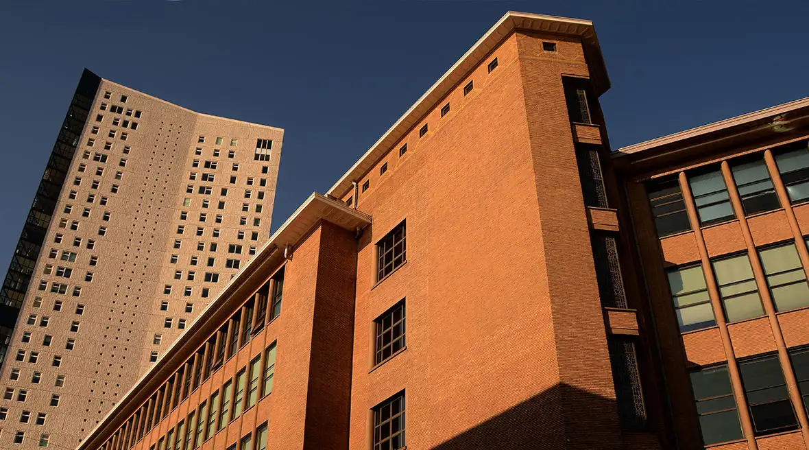 A stark modern high rise apartment building and a lower office type building